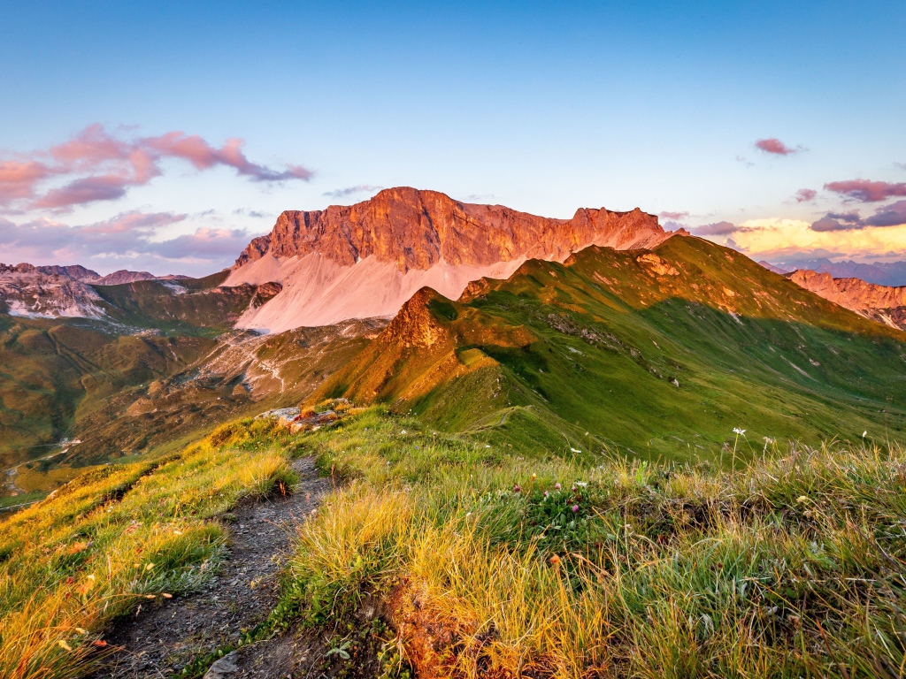 Солнце встает над зелеными горами
