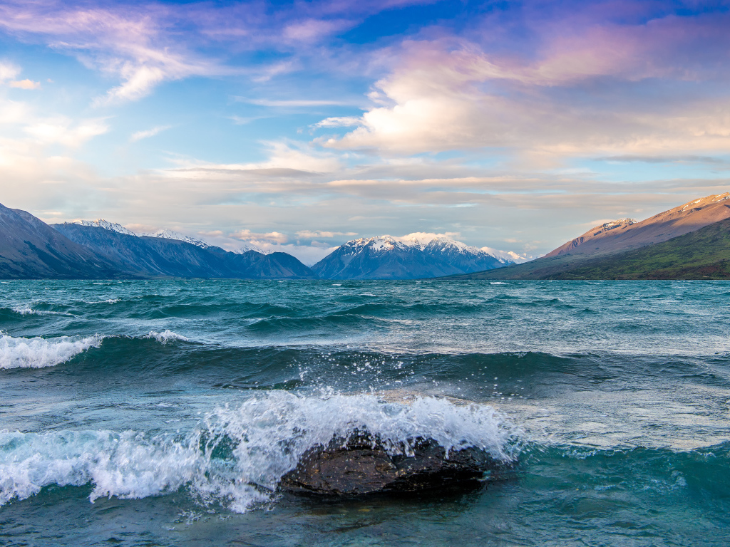 Волны бьются об камни в заливе у гор