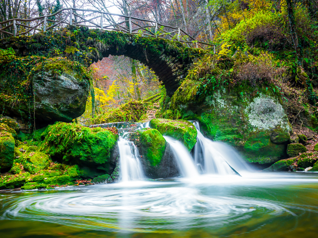 Водопад под старым покрытым мхом мостом