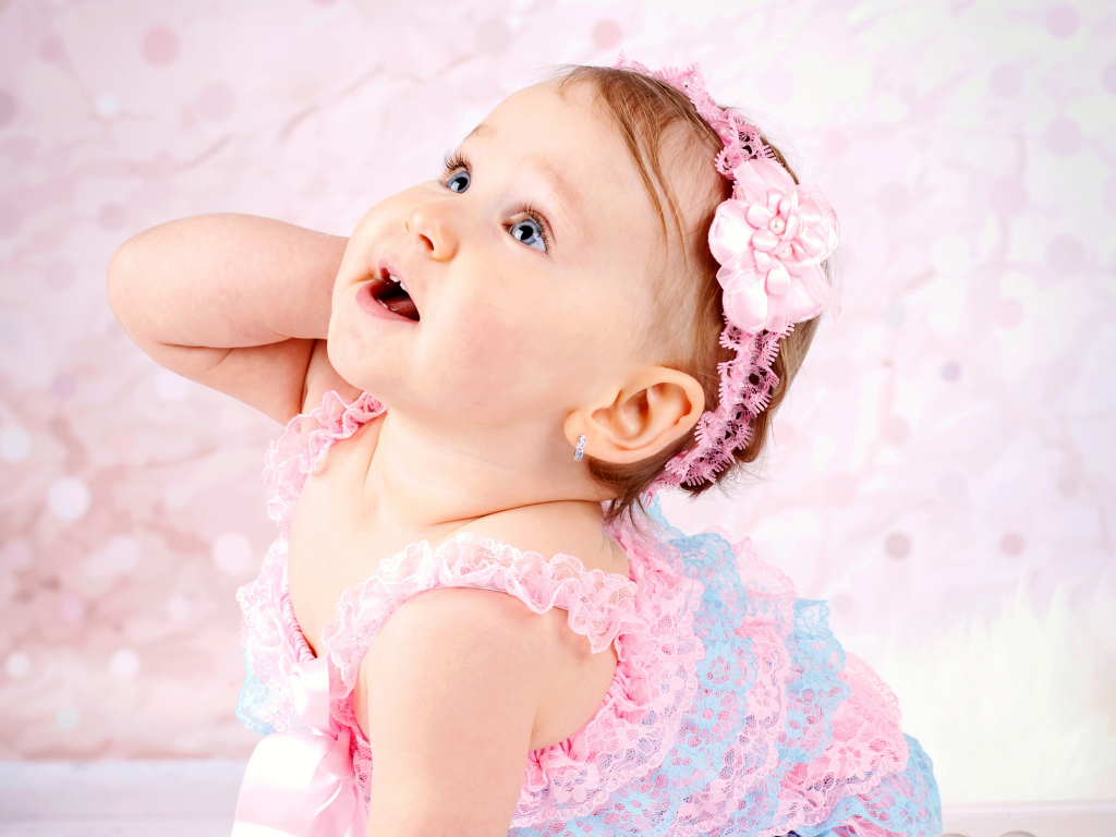 Милая голубоглазая девочка с розовой повязкой на голове