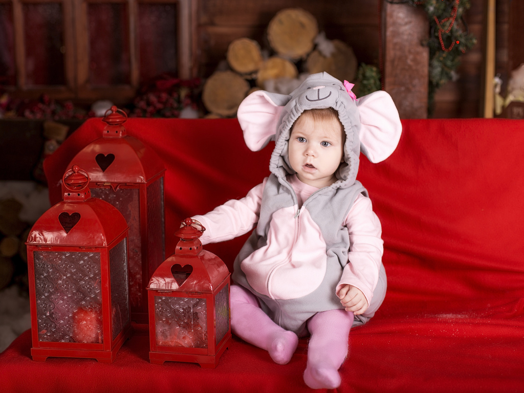 Маленький мальчик в костюме мышонка с фонарями на диване