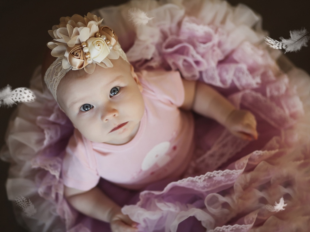 Маленькая милая девочка в пышном платье с повязкой на голове