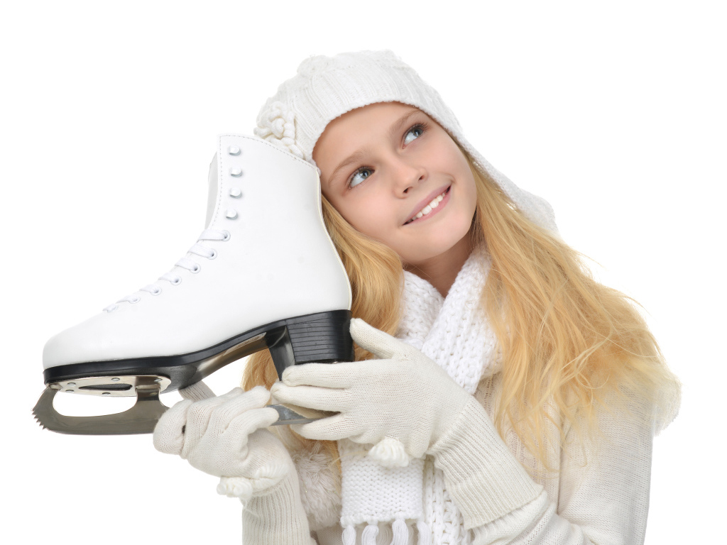 Маленькая девочка блондинка с коньком в руках на белом фоне