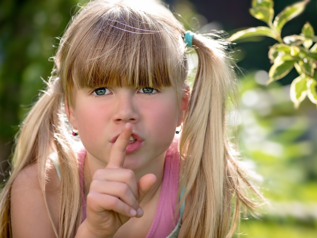 Маленькая зеленоглазая девочка с пальцем у рта 