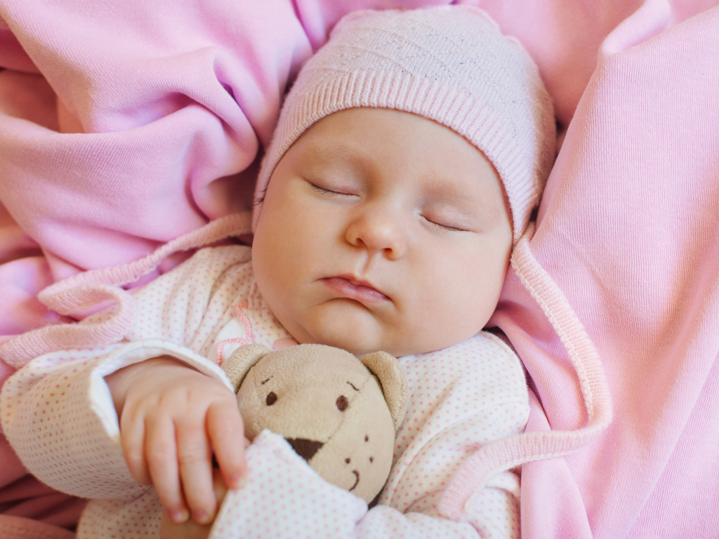 Спящий ребенок обнимает любимую игрушку