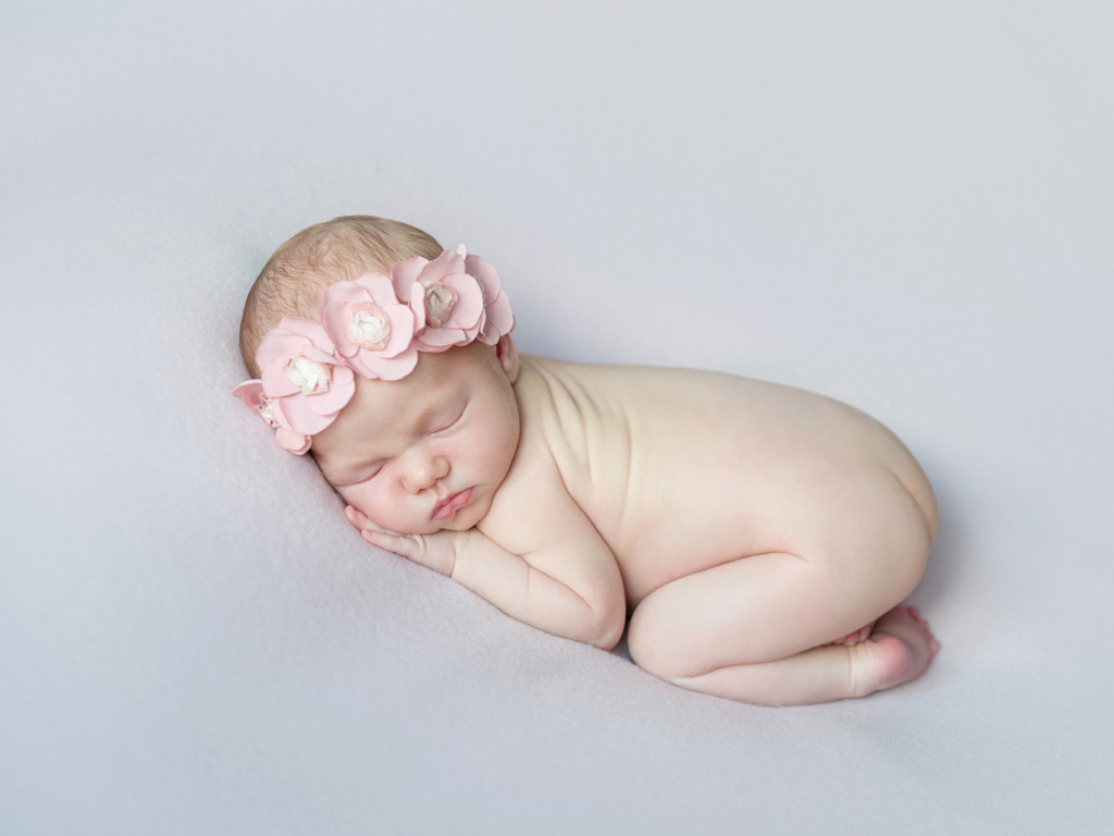 Спящая девочка с розовым венком на голове