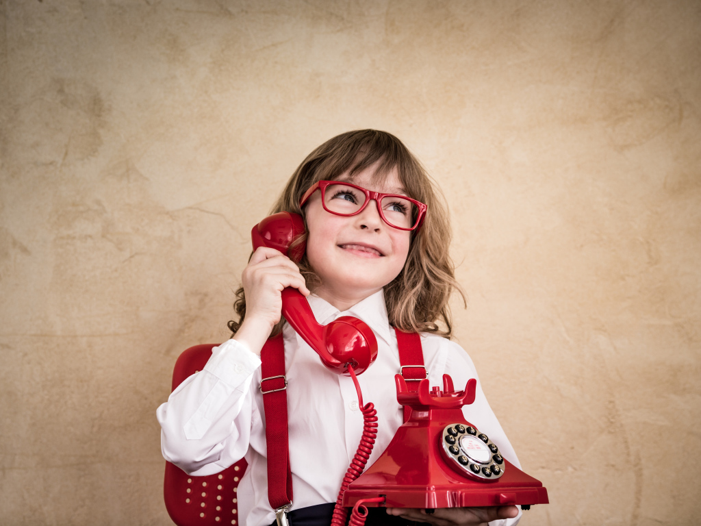 Улыбающийся мальчик с красным телефоном