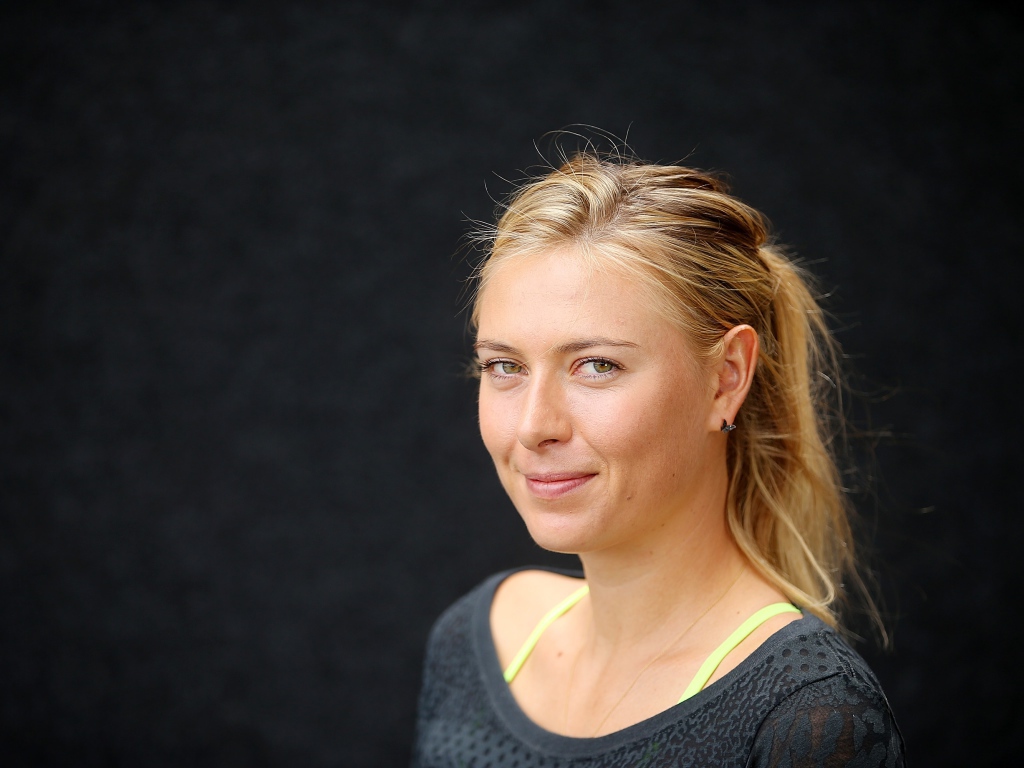 Улыбающаяся блондинка, теннисистка Мария Шарапова на сером фоне