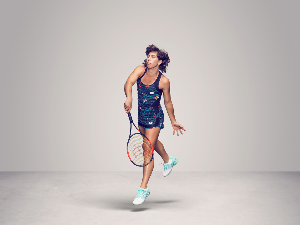 Испанская теннисистка Карла Суарес Наварро с ракеткой на сером фоне