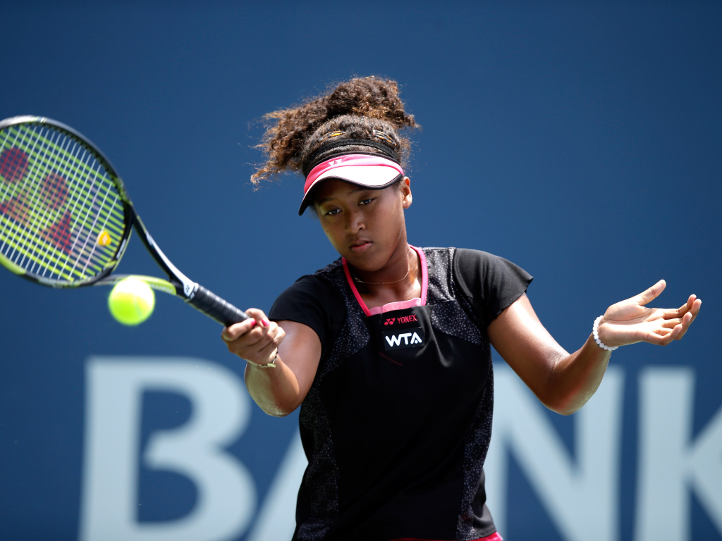 Tennis player Naomi Osaka on the court with a racket