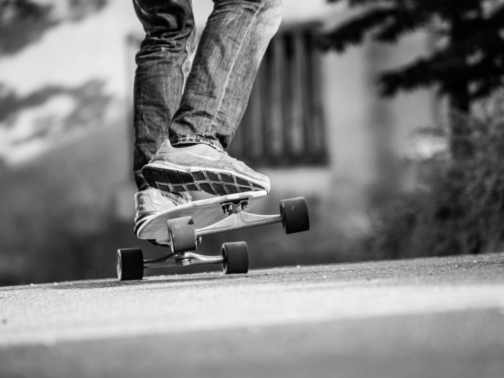 Парень катается на скейтборде по асфальту