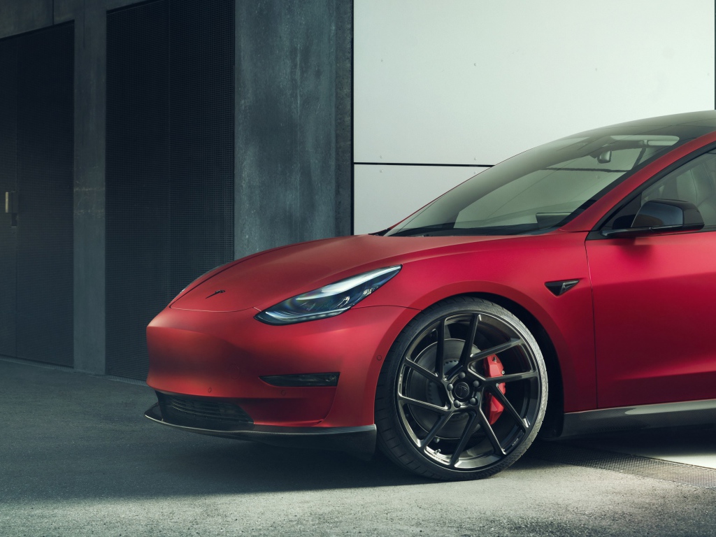 Красный автомобиль Tesla Model 3 2019 года выезжает в гаража