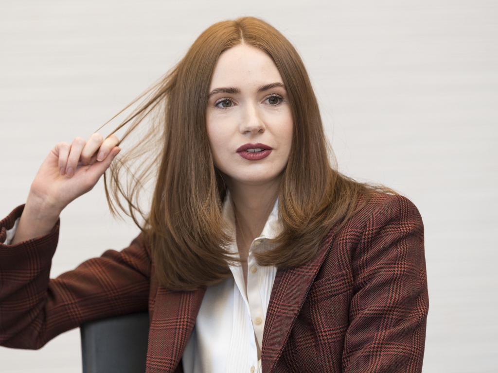 Актриса Карен Гиллан в пиджаке держит волосы