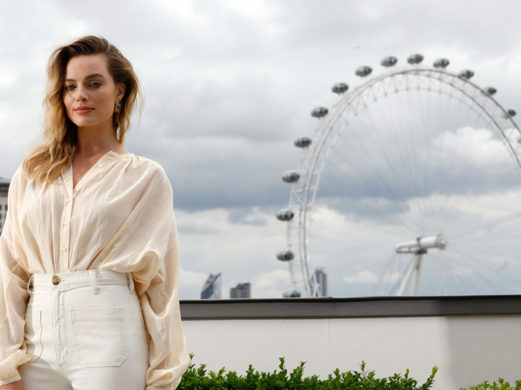 Актриса Марго Робби на  фоне аттракциона  колесо обозрения