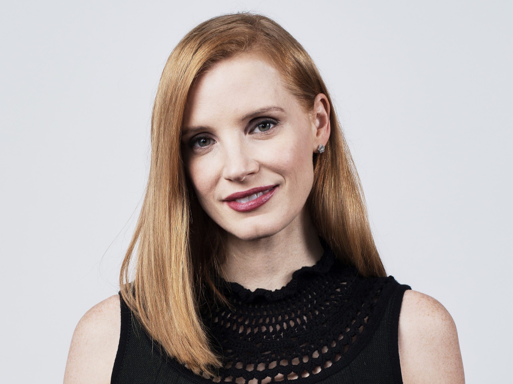 Красивая рыжеволосая актриса Джессика Честейн на сером фоне