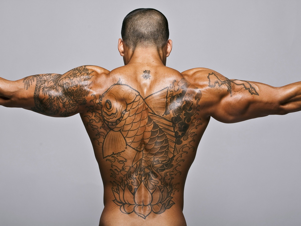 Big tattoo with a fish on the back of a man