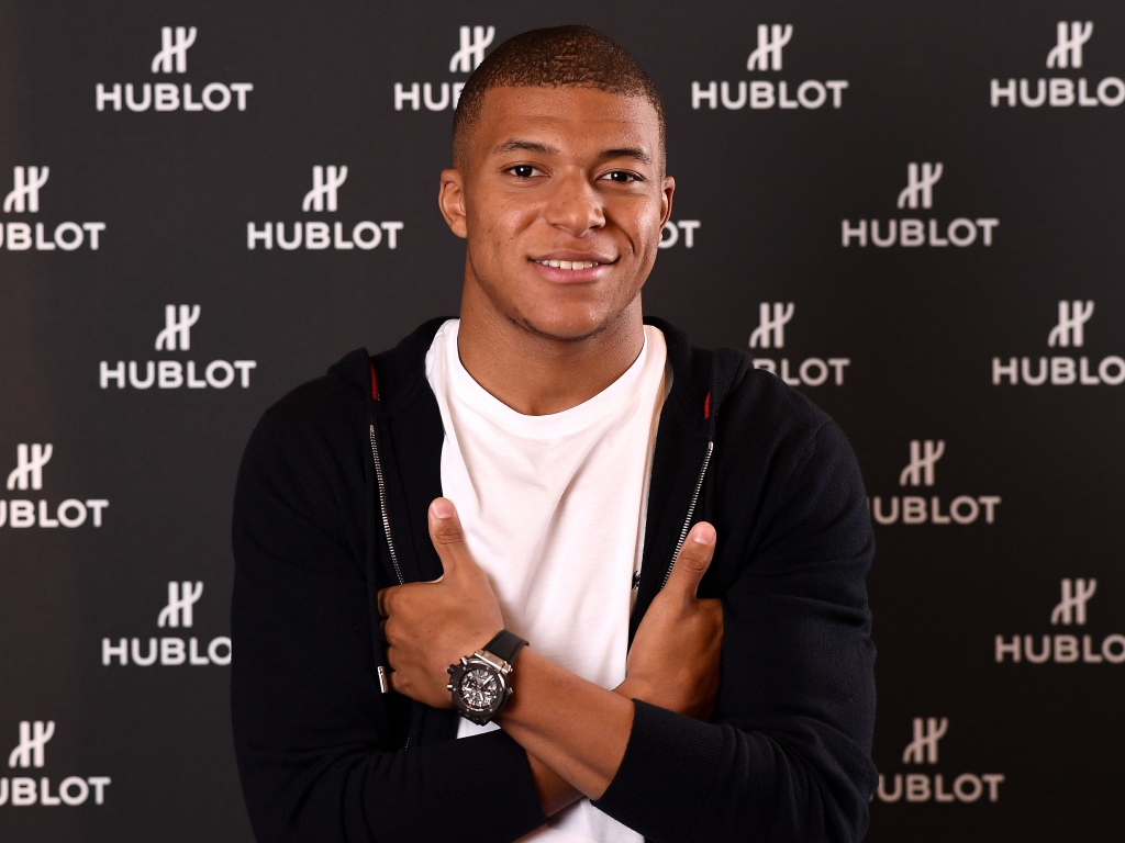 Футболист Килиан Мбаппе в костюме с часами на руке