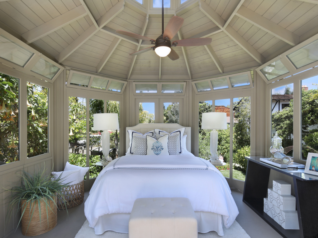 Большая спальная комната с окнами и белой кроватью 