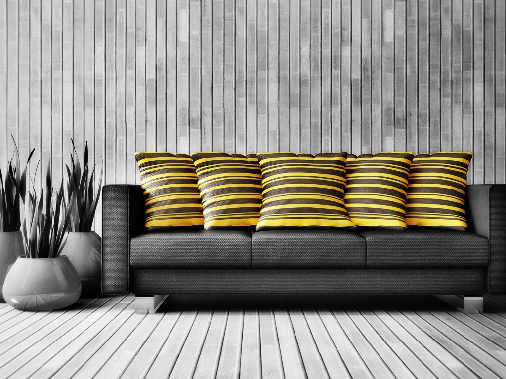 Большой черный кожаный диван с подушками у стены