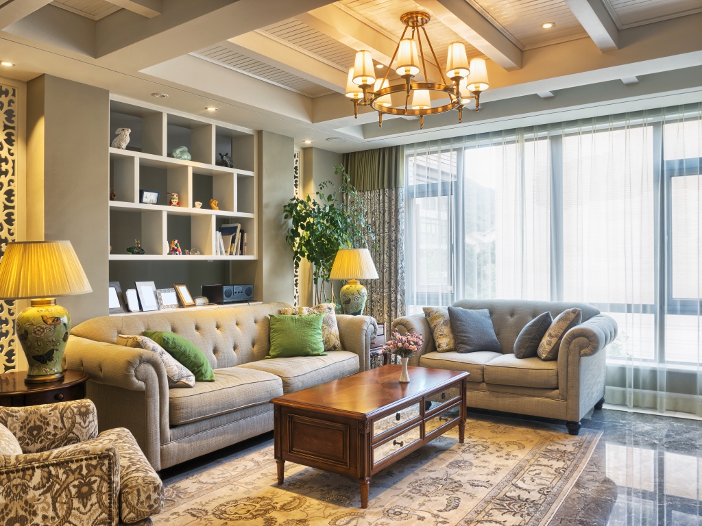 Много мягкой мебели в гостиной комнате с люстрой