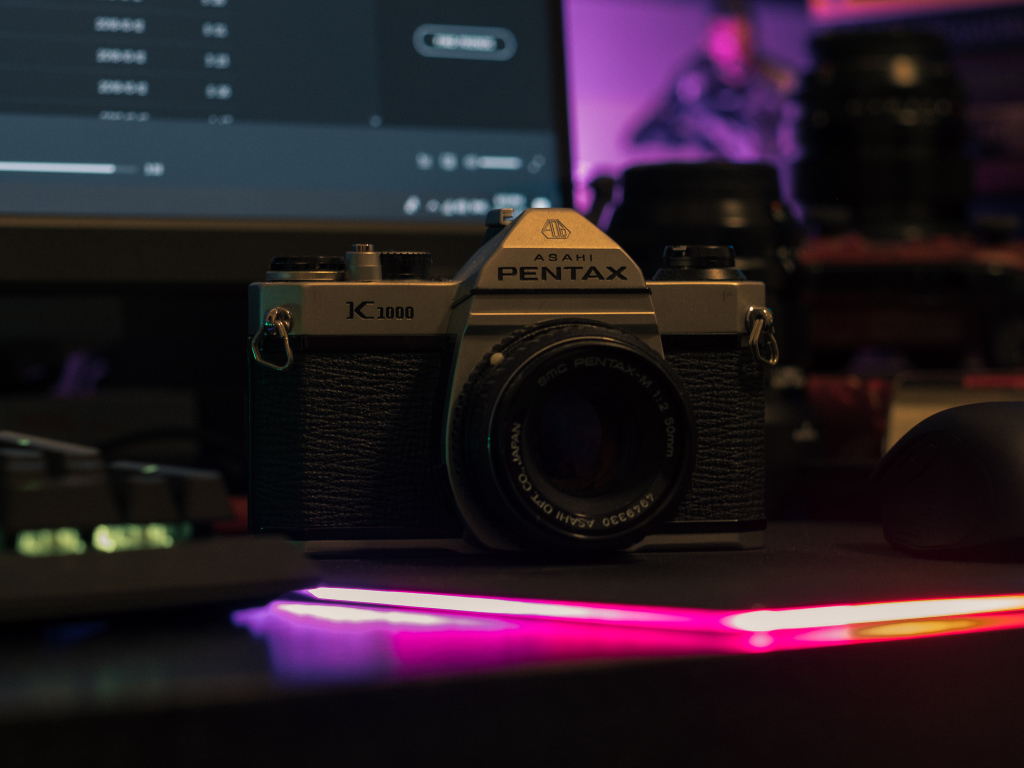 Фотоаппарат Pentax на столе с компьютером