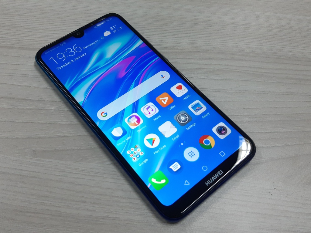 Смартфон Huawei Y7 Pro, 2019 года лежит на деревянном столе