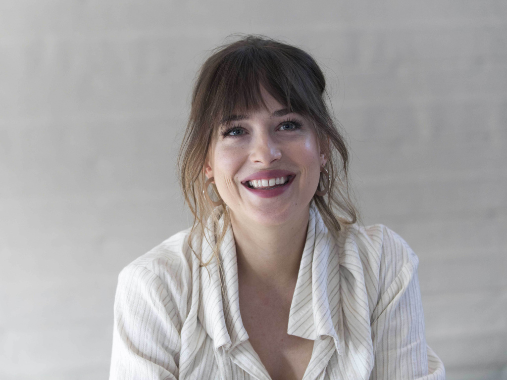 Улыбающаяся девушка актриса Дакота Джонсон в рубашке