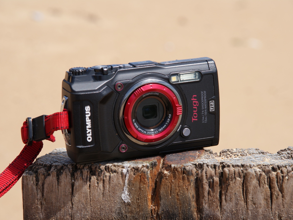 Стильный фотоаппарат Olympus Tough TG-5 стоит на пне