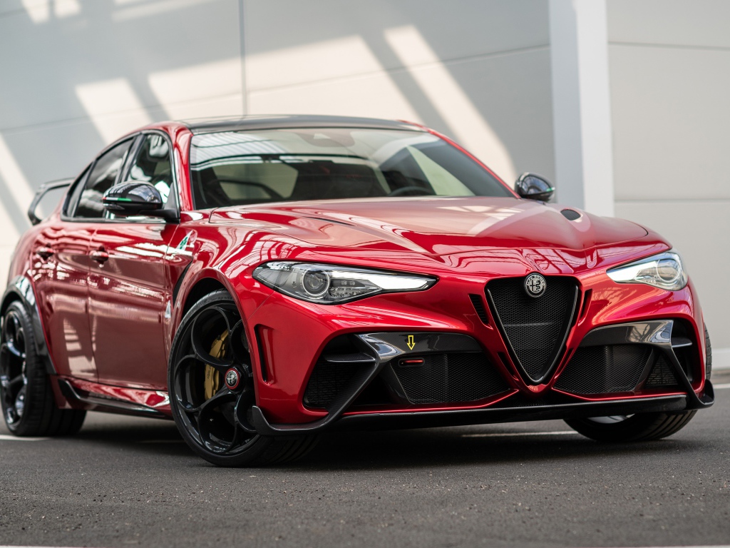 Красный автомобиль Alfa Romeo Giulia GTAm 2020 года у гаража