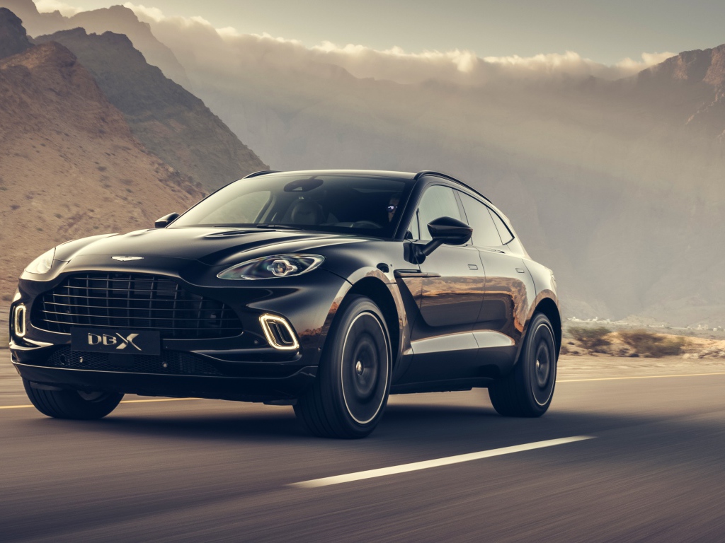Черный автомобиль Aston Martin DBX 2020 года на трассе