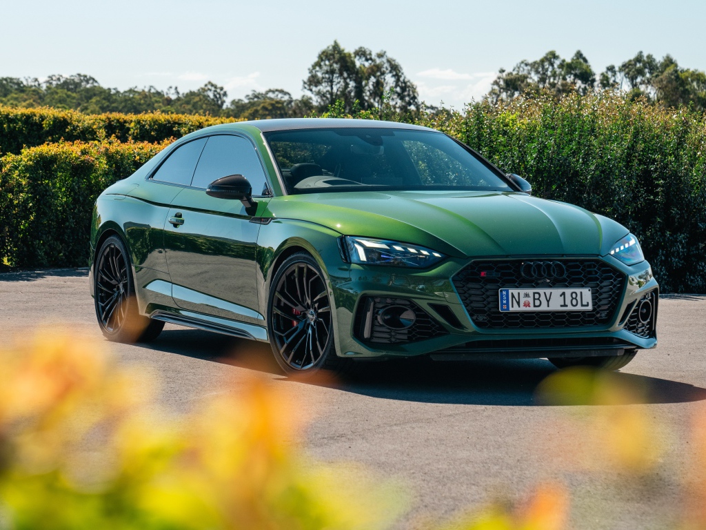 Зеленый автомобиль Audi RS 5 Coupé 2020  года в лучах солнца