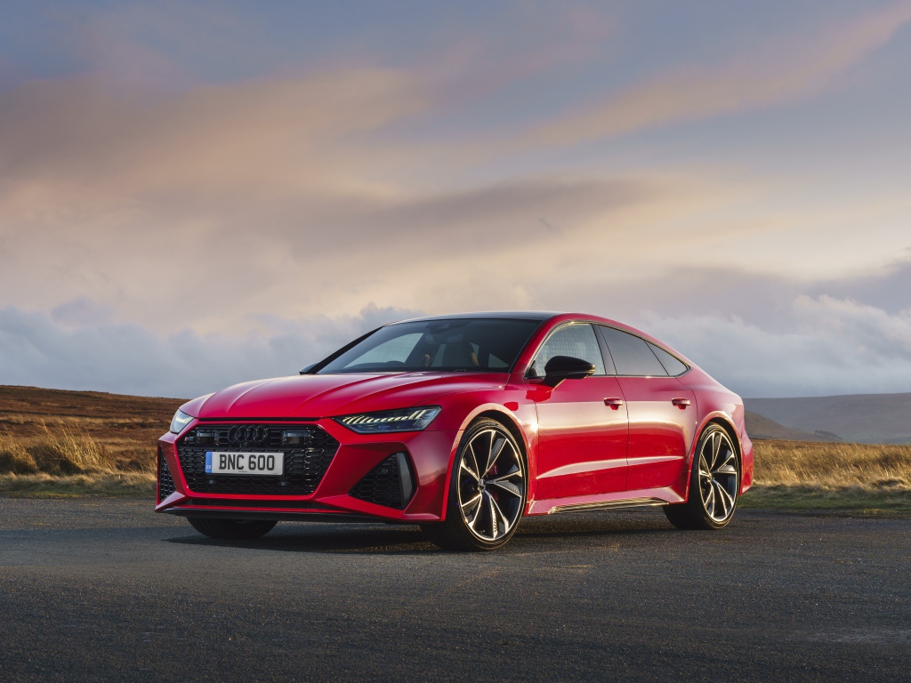 Красный автомобиль Audi RS 7 Sportback 2020 года на дороге 