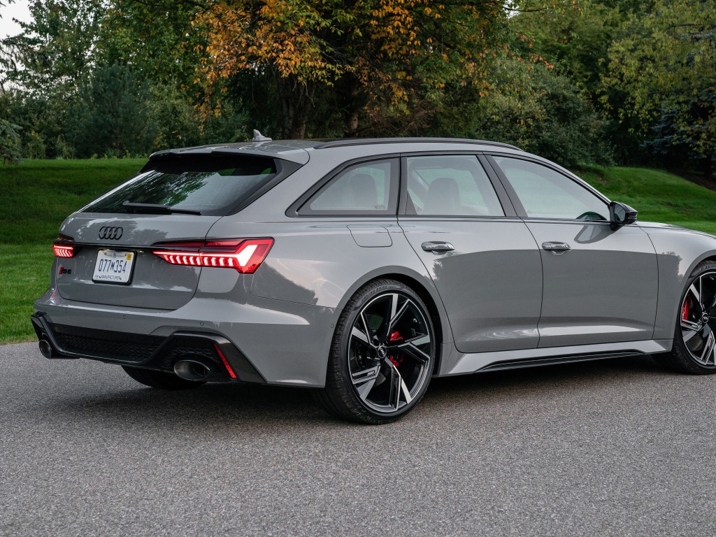 Серебристый автомобиль Audi RS 6 Avant, 2021 года вид сзади