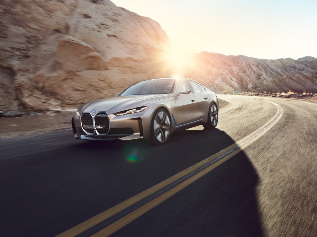 Автомобиль BMW Concept I4 2020 года у гор в лучах солнца