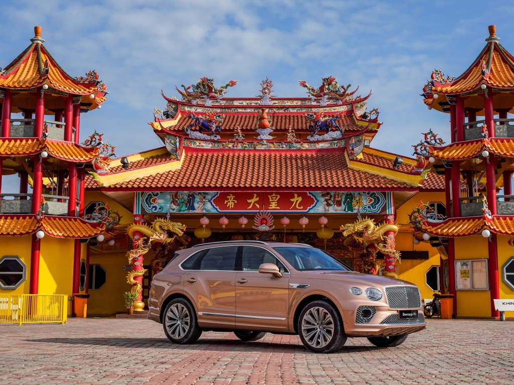 Коричневый автомобиль Bentley Bentayga V8 2020 года на фоне красивого здания