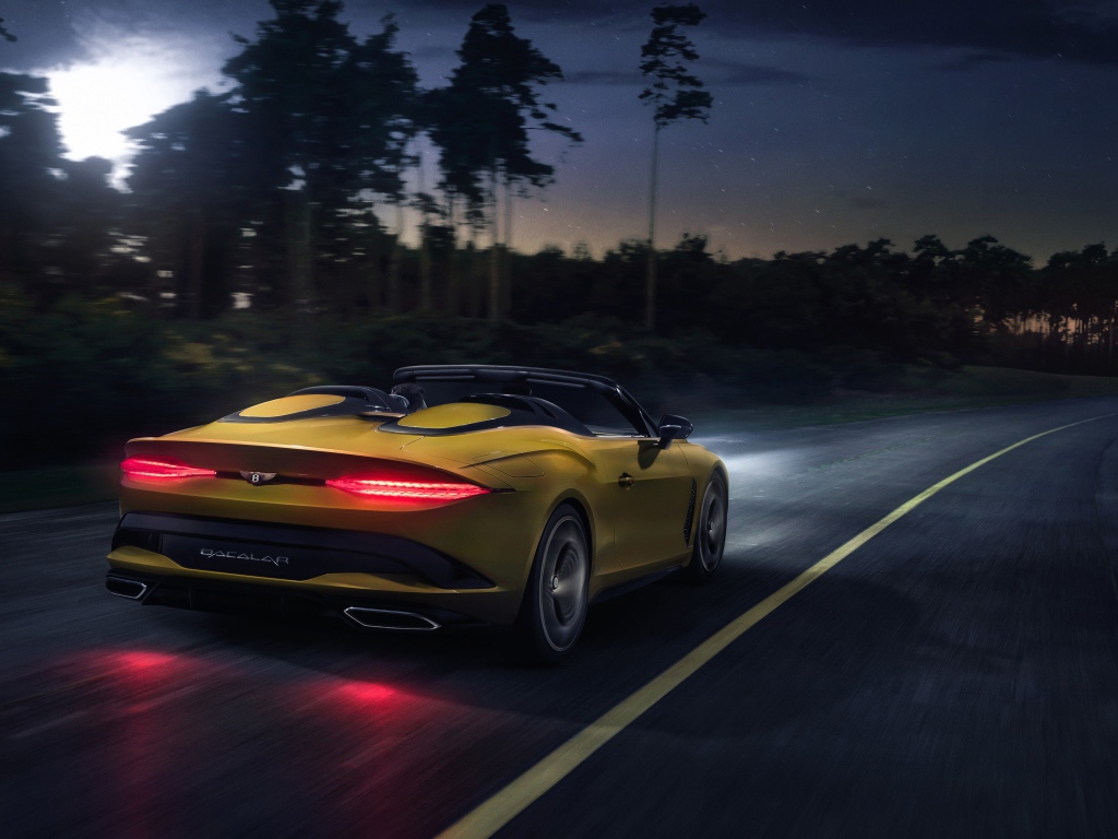 Желтый автомобиль Bentley Mulliner Bacalar 2020 года на ночной трассе 