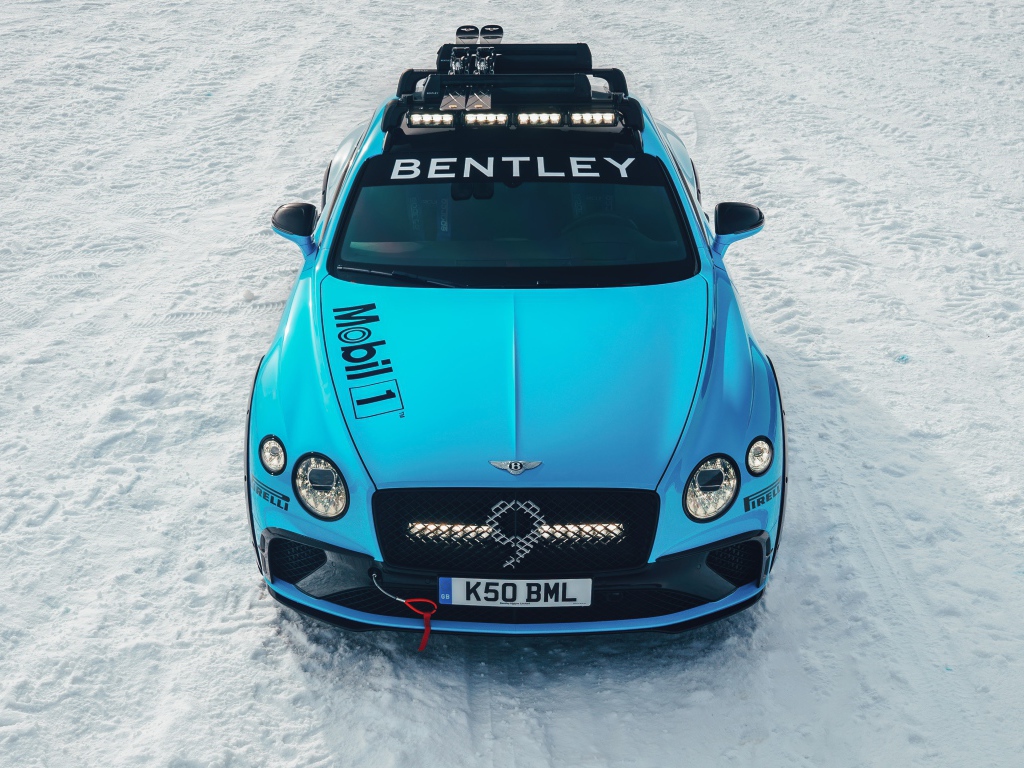 Голубой автомобиль Bentley Continental GT Ice Race 2020 года стоит на заснеженной дороге 