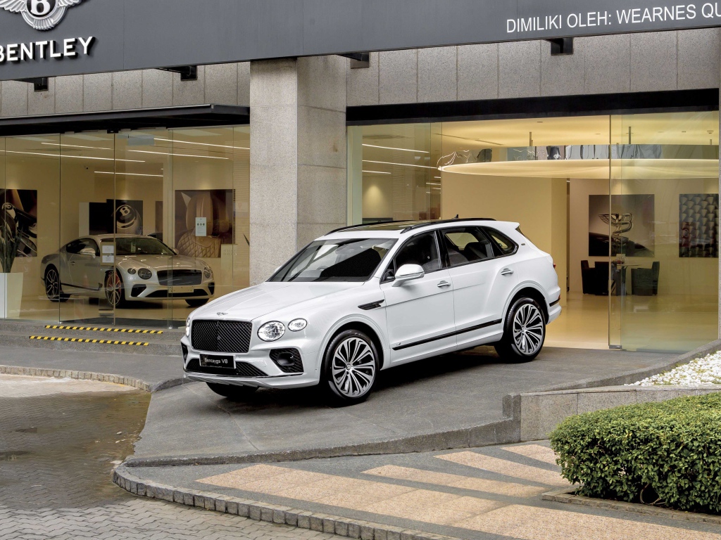 Белый автомобиль Bentley Bentayga V8 First Edition 2020 года выезжает из автосалона 