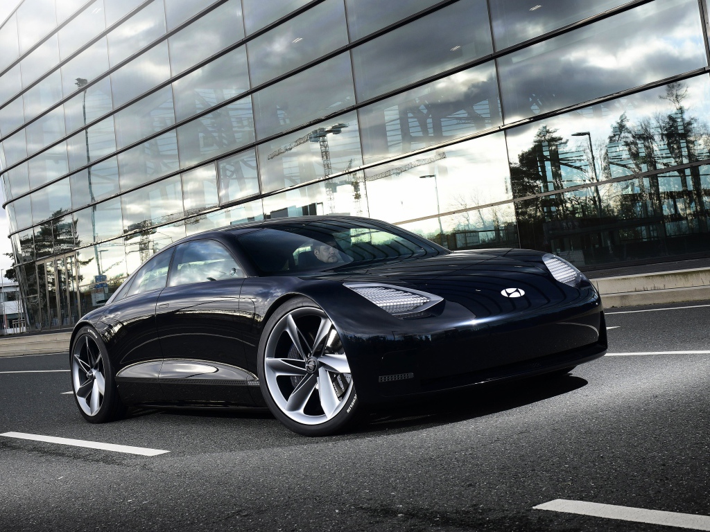 Черный автомобиль Hyundai Prophecy 2020 года у стеклянного здания 