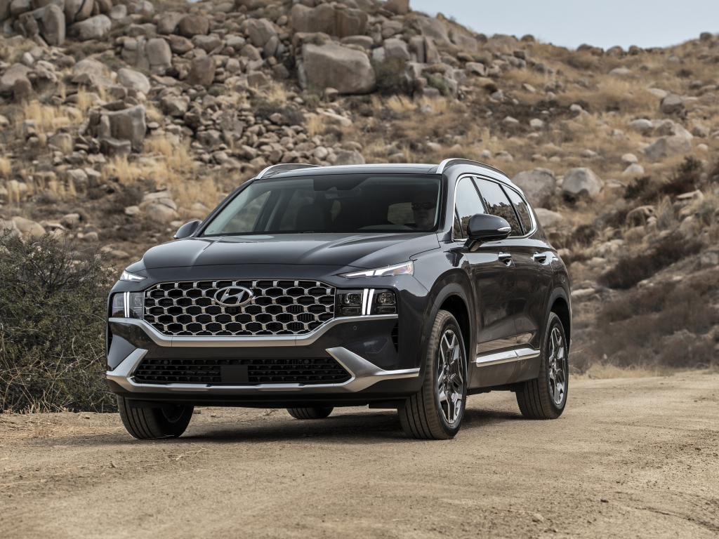 Черный автомобиль  Hyundai Santa Fe Hybrid, 2021 года у камней