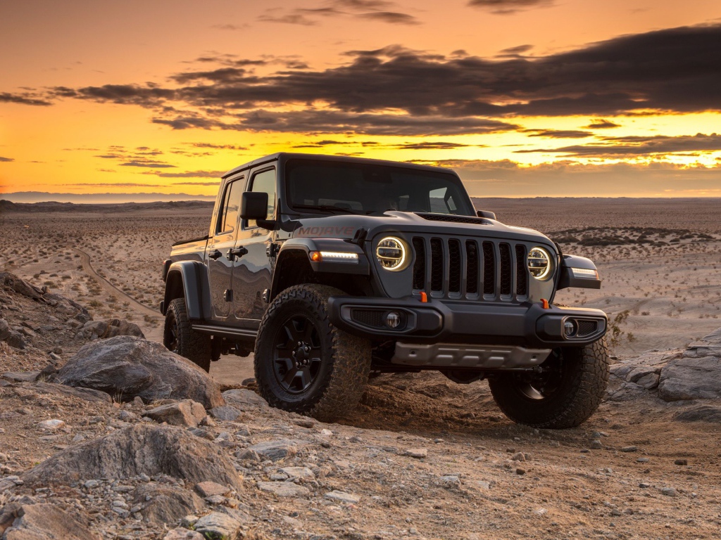 Черный внедорожник Jeep Gladiator Mojave, 2020 года в пустыне на закате