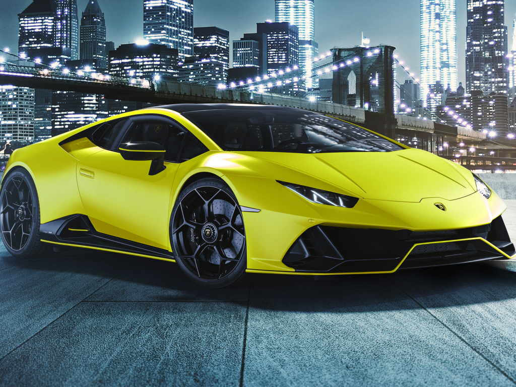 Желтый автомобиль Lamborghini Huracán EVO 2021 года на фоне города