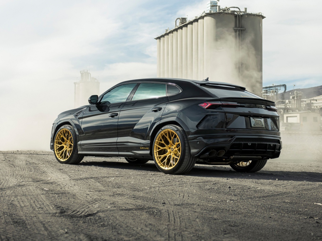 Черный внедорожник  Lamborghini Urus 2020 года на фоне завода вид сзади