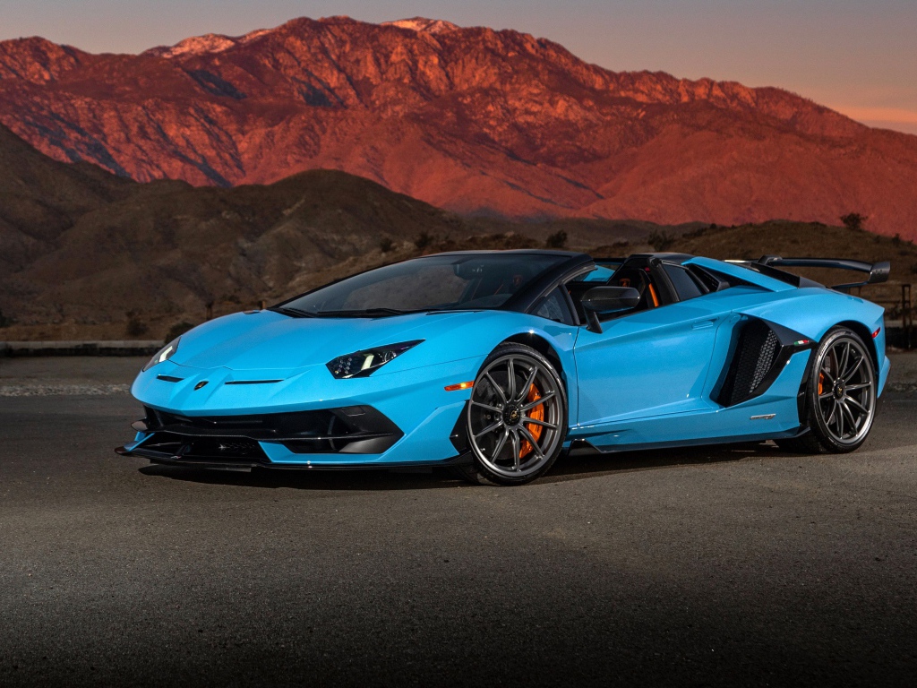 Голубой спортивный автомобиль Lamborghini Aventador SVJ Roadster, 2020 года на фоне гор