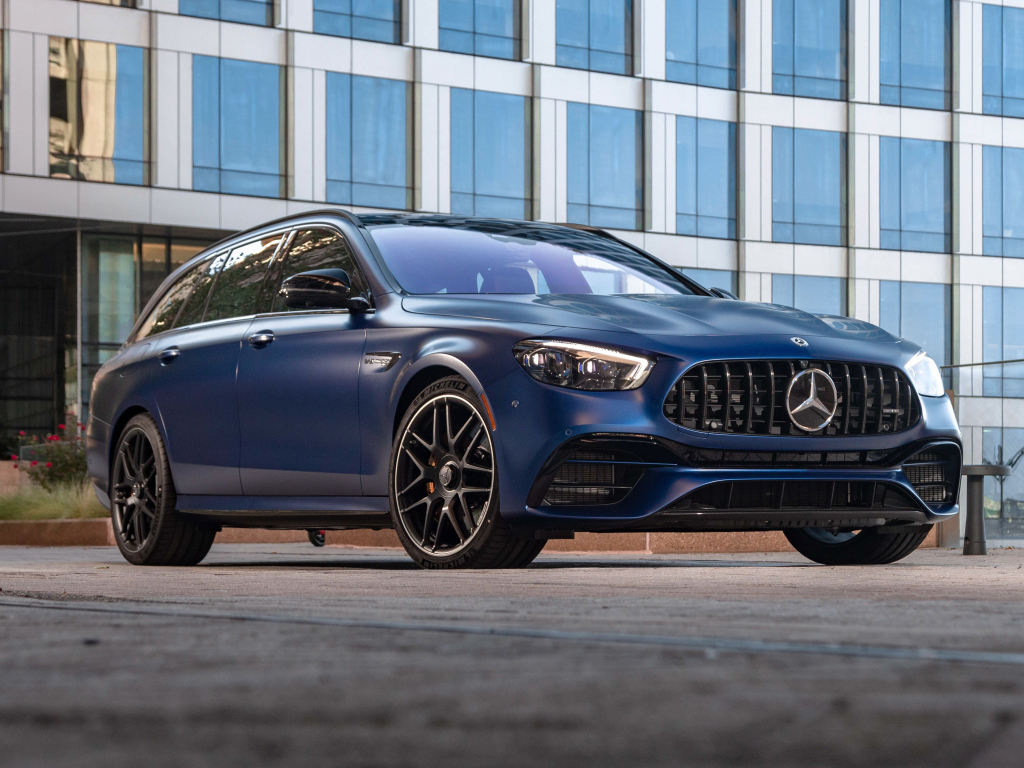 Синий автомобиль Mercedes-AMG E 63 S 4MATIC+, 2021 года на фоне дома