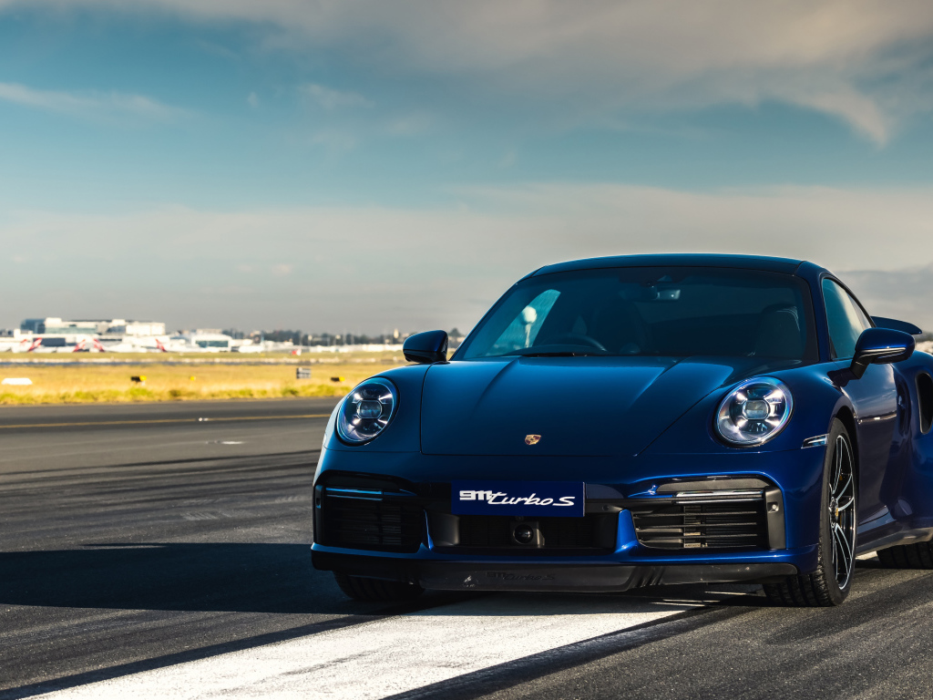 Синий автобус Porsche 911 Turbo S 2020 года на трассе