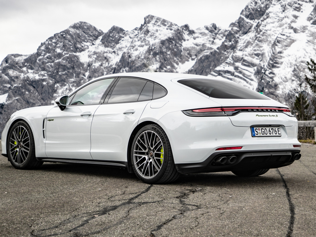 Белый автомобиль Porsche Panamera Turbo S E-Hybrid 2021 года на фоне гор