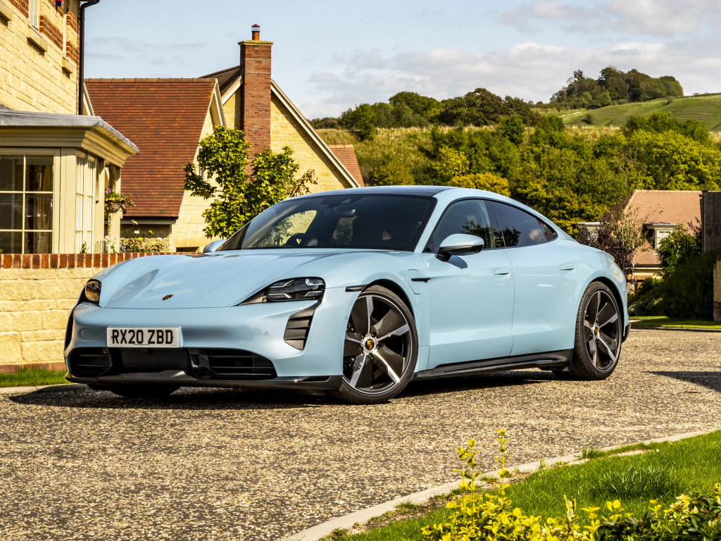Голубой автомобиль Porsche Taycan 4S 2021 года у дома вид спереди