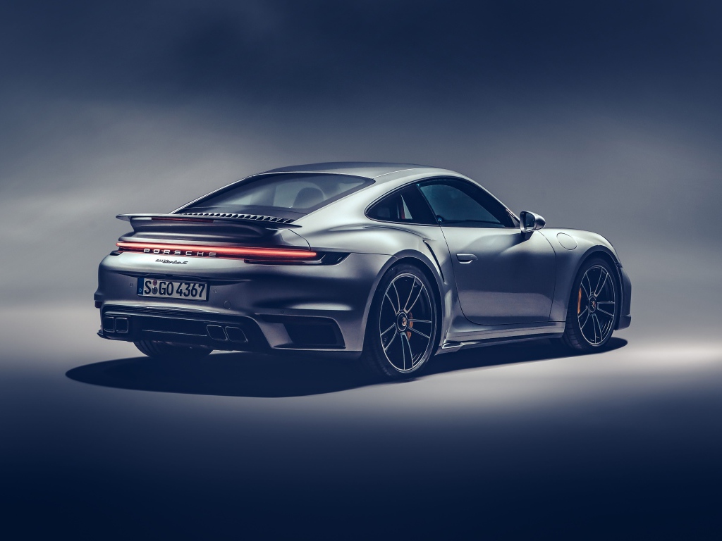 Автомобиль Porsche 911 Turbo S 2020 года на сером фоне вид сзади
