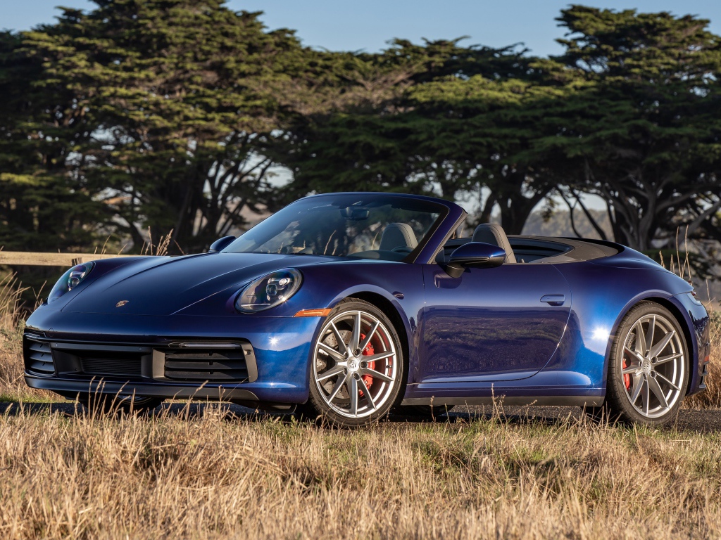 Автомобиль Porsche 911 Carrera S, 2020 года на фоне деревьев 